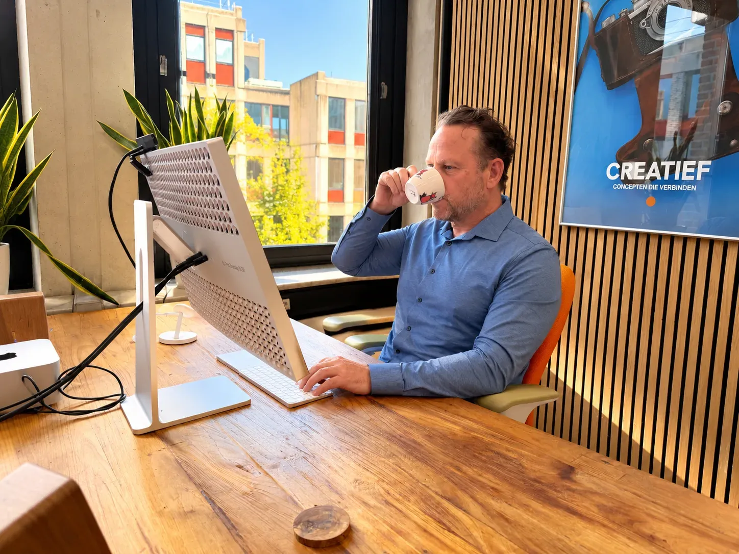 Dennis drinkt koffie aan zijn bureau bij Globeview Webdesign