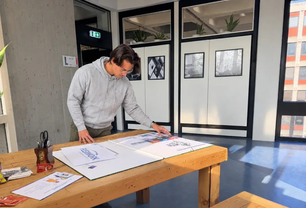 Julian bekijkt drukwerk en ontwerpen op de presentatietafel in Carbon6