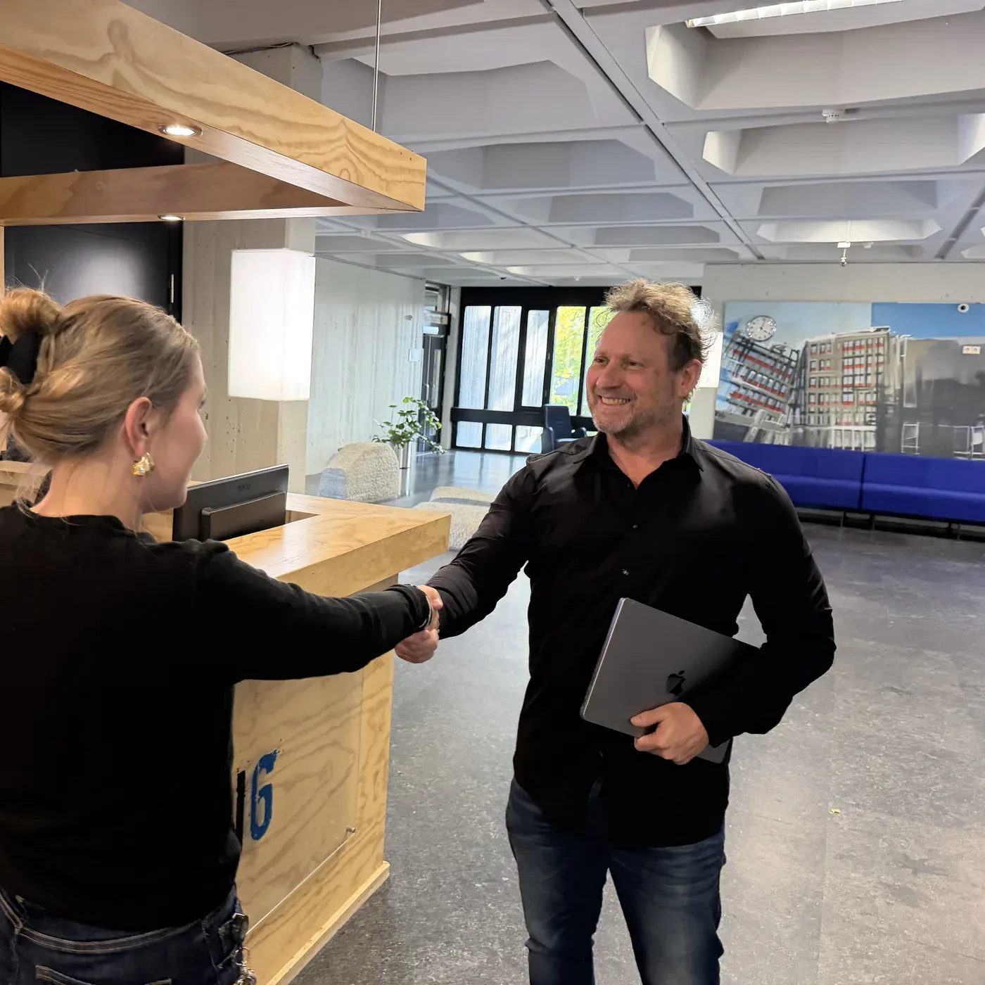 Dennis heet een bezoeker welkom bij de receptie van Carbon6 in Heerlen